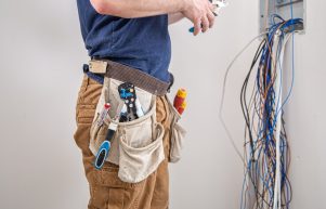 electrician-builder-work-examines-cable-connection-electrical-line-fuselage-industrial-switchboard-professional-overalls-with-electrician-s-tool_169016-8635